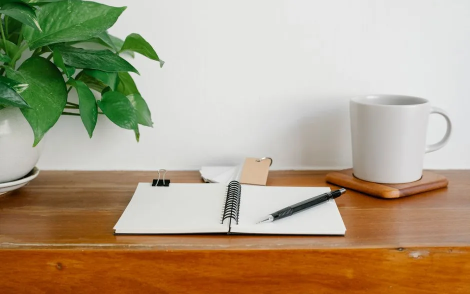 Carnet ouvert sur une table en bois dans un intérieur lumineux